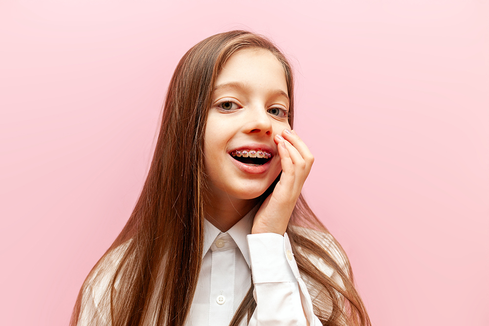 A little girl showing her teeth with braces