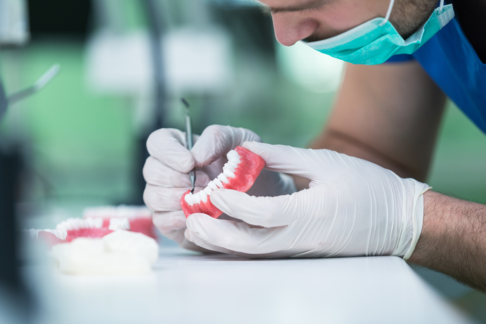 A dentist working on dentures for a client