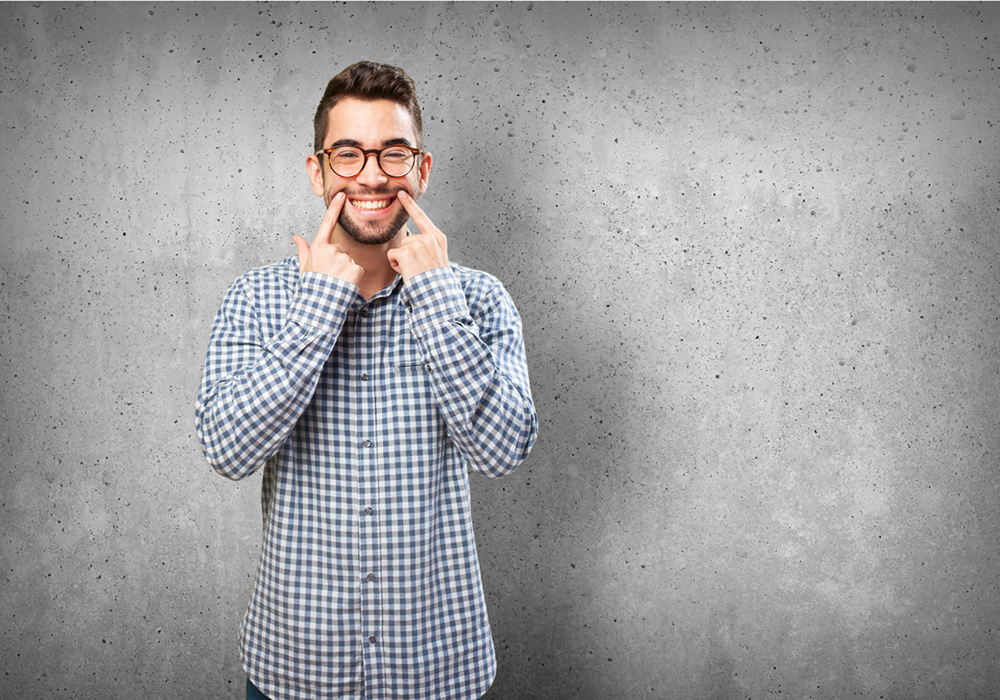 Man smiling and showing his perfect teeth after full-mouth rehabilitation